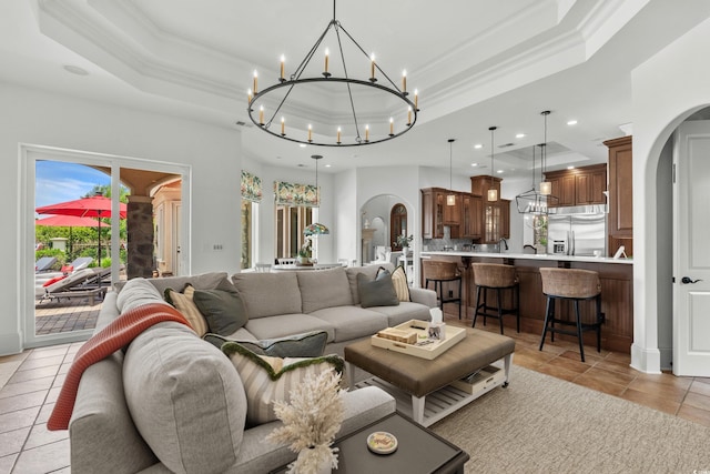 9737 Catalonia Ct, Myrtle Beach, SC 29579 - living room featuring arched walkways, a tray ceiling, a chandelier, recessed lighting, and crown molding