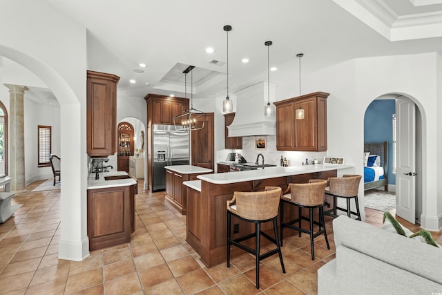 9737 Catalonia Ct, Myrtle Beach, SC 29579 - kitchen featuring built in refrigerator, a raised ceiling, arched walkways, recessed lighting, and crown molding