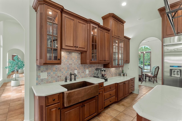 9737 Catalonia Ct, Myrtle Beach, SC 29579 - kitchen with stainless steel fridge, arched walkways, light tile patterned floors, glass insert cabinets, and recessed lighting