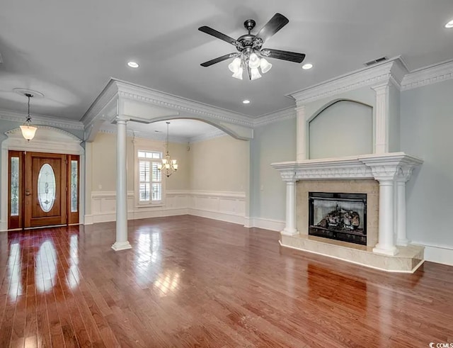 1613 James Island Ave, North Myrtle Beach, SC 29582 - unfurnished living room featuring ornate columns, wood finished floors, a fireplace, crown molding, and a ceiling fan