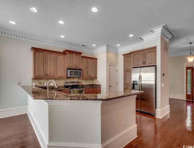 1613 James Island Ave, North Myrtle Beach, SC 29582 - kitchen with stainless steel appliances, dark stone counters, tasteful backsplash, a peninsula, and ornamental molding