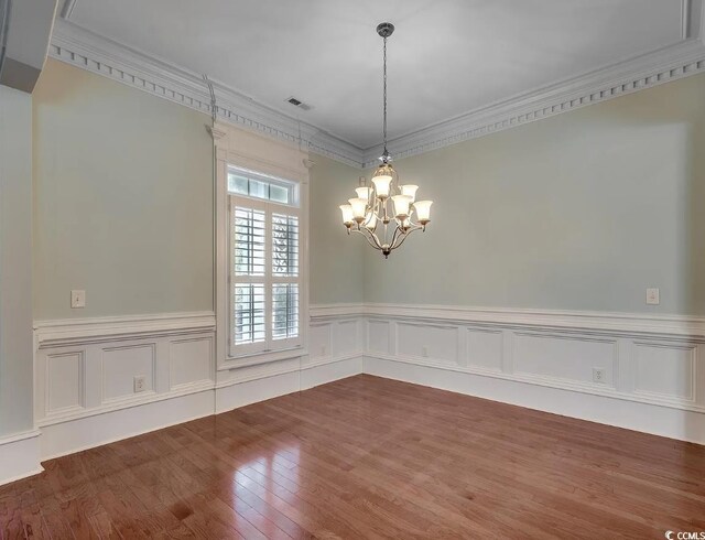 1613 James Island Ave, North Myrtle Beach, SC 29582 - unfurnished dining area featuring a chandelier, dark wood-type flooring, crown molding, wainscoting, and a decorative wall
