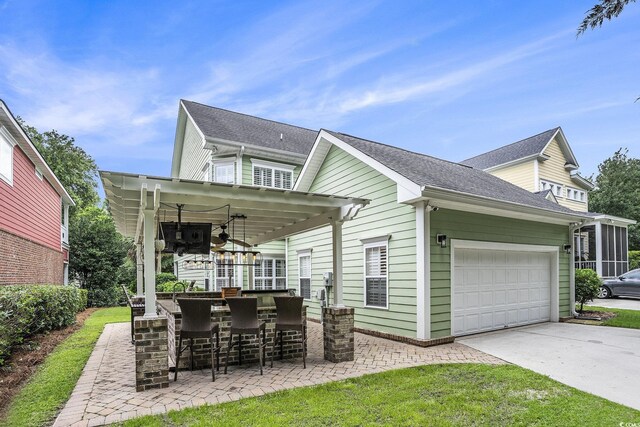 1613 James Island Ave, North Myrtle Beach, SC 29582 - back of property featuring concrete driveway, an attached garage, and a ceiling fan