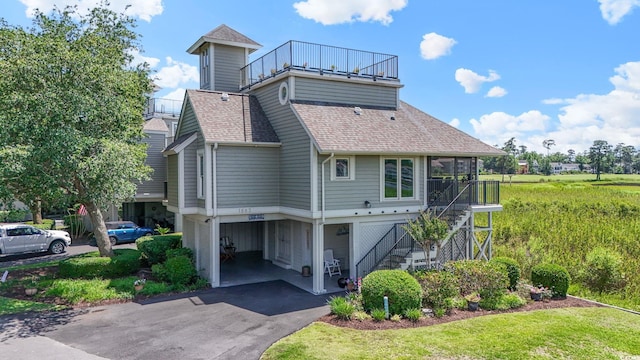 1663 Harbor Dr, North Myrtle Beach, SC 29582 - rear view of house with stairway, a carport, a shingled roof, driveway, and a balcony