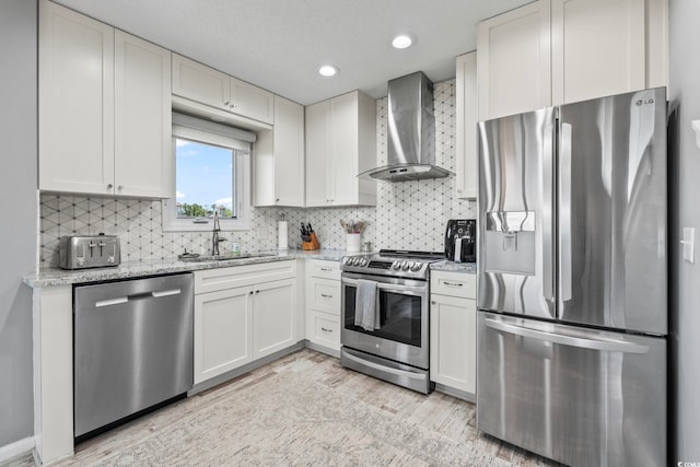 1663 Harbor Dr, North Myrtle Beach, SC 29582 - kitchen featuring stainless steel appliances, wall chimney exhaust hood, light wood-style floors, light stone counters, and tasteful backsplash