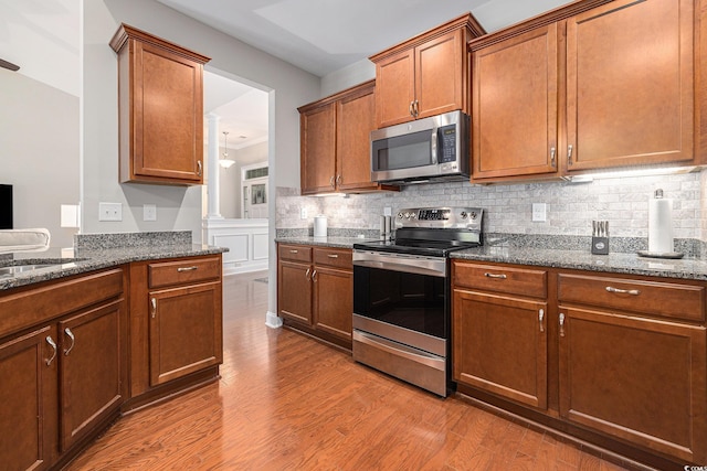 2010 Chattooga Ct, Myrtle Beach, SC 29588 - kitchen featuring appliances with stainless steel finishes, wood finished floors, dark stone countertops, and tasteful backsplash