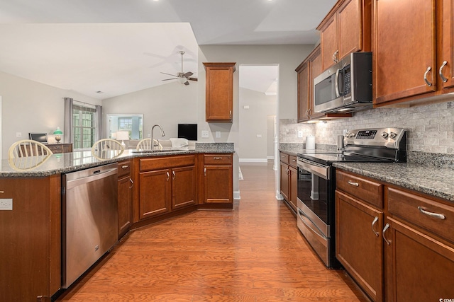 2010 Chattooga Ct, Myrtle Beach, SC 29588 - kitchen featuring appliances with stainless steel finishes, vaulted ceiling, a peninsula, ceiling fan, and wood finished floors