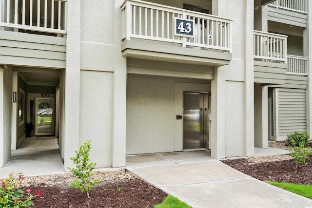 1401 Lighthouse Dr Unit 4334, North Myrtle Beach, SC 29582 - view of exterior entry with elevator, a balcony, and stucco siding