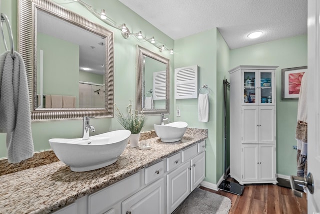 1401 Lighthouse Dr Unit 4334, North Myrtle Beach, SC 29582 - bathroom with wood finished floors, double vanity, a textured ceiling, and a shower with door