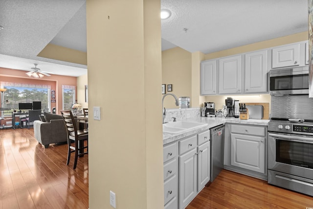 1401 Lighthouse Dr Unit 4334, North Myrtle Beach, SC 29582 - kitchen featuring appliances with stainless steel finishes, wood finished floors, open floor plan, light countertops, and a textured ceiling