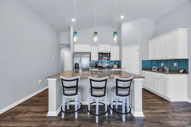 1520 Jardine Loop, Little River, SC 29566 - kitchen with stainless steel appliances, backsplash, a breakfast bar area, white cabinets, and high vaulted ceiling