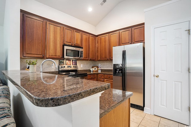364 Vesta Dr, Myrtle Beach, SC 29579 - kitchen with stainless steel appliances, a peninsula, vaulted ceiling, light tile patterned floors, and tasteful backsplash