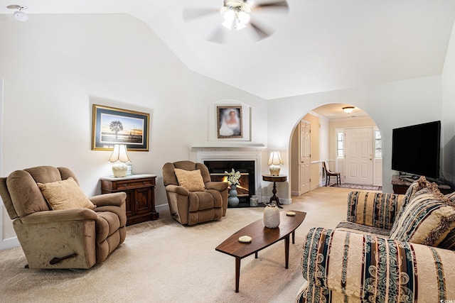 364 Vesta Dr, Myrtle Beach, SC 29579 - living room with arched walkways, ceiling fan, vaulted ceiling, light carpet, and a glass covered fireplace