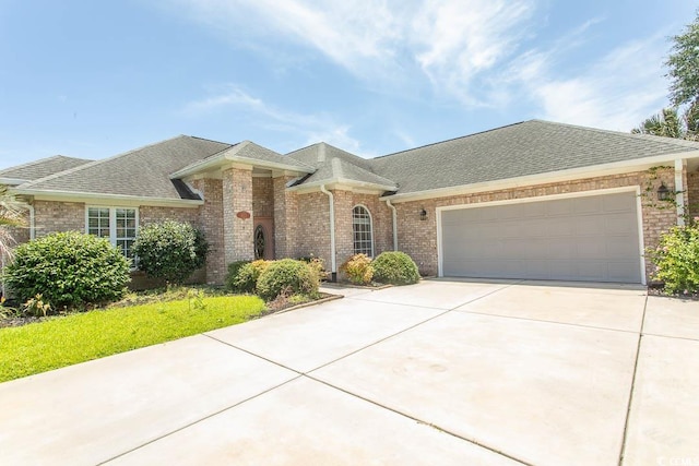 413 Sea Vista Ln, North Myrtle Beach, SC 29582 - view of front facade with driveway, a garage, roof with shingles, and brick siding