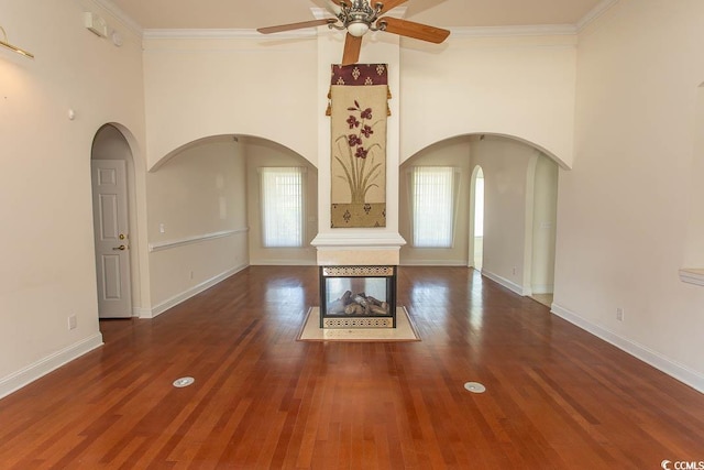 413 Sea Vista Ln, North Myrtle Beach, SC 29582 - unfurnished living room featuring ceiling fan, plenty of natural light, wood finished floors, ornamental molding, and arched walkways