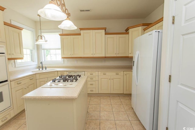 413 Sea Vista Ln, North Myrtle Beach, SC 29582 - kitchen featuring white appliances, light countertops, a kitchen island, hanging light fixtures, and light tile patterned flooring