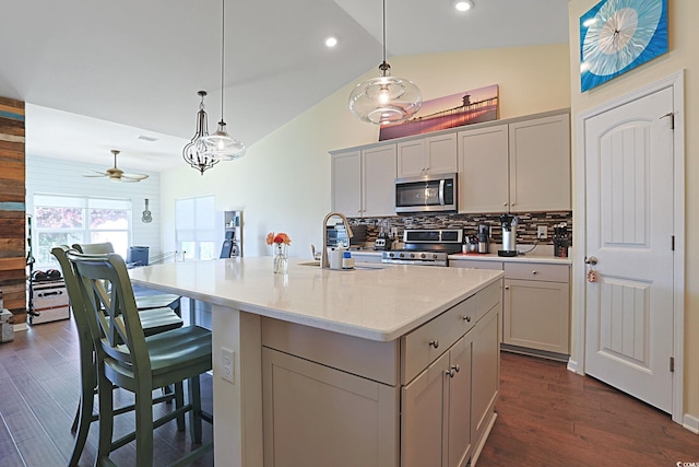 232 Angel Wing Dr, Myrtle Beach, SC 29588 - kitchen featuring appliances with stainless steel finishes, lofted ceiling, tasteful backsplash, an island with sink, and a breakfast bar