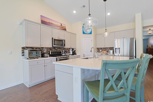 232 Angel Wing Dr, Myrtle Beach, SC 29588 - kitchen featuring stainless steel appliances, a breakfast bar area, tasteful backsplash, light countertops, and high vaulted ceiling