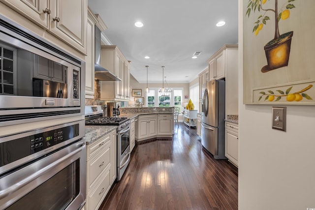 124 Turtle Creek Dr, Pawleys Island, SC 29585 - kitchen featuring stainless steel appliances, a peninsula, cream cabinetry, recessed lighting, and light stone counters