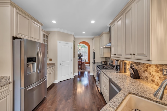 124 Turtle Creek Dr, Pawleys Island, SC 29585 - kitchen with appliances with stainless steel finishes, cream cabinets, crown molding, backsplash, and arched walkways
