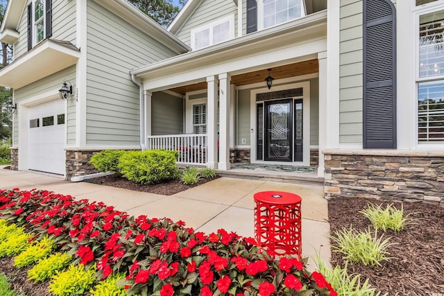124 Turtle Creek Dr, Pawleys Island, SC 29585 - property entrance featuring stone siding, a porch, and a garage