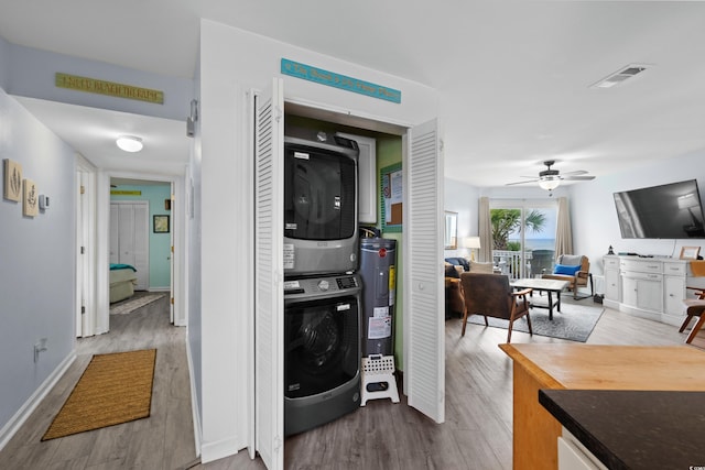 1217 S Ocean Blvd Unit 5, Surfside Beach, SC 29575 - laundry area featuring stacked washing machine and dryer, water heater, wood finished floors, and a ceiling fan