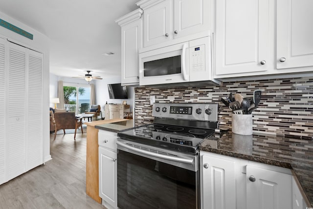 1217 S Ocean Blvd Unit 5, Surfside Beach, SC 29575 - kitchen with stainless steel range with electric stovetop, white microwave, tasteful backsplash, white cabinets, and light wood-style flooring