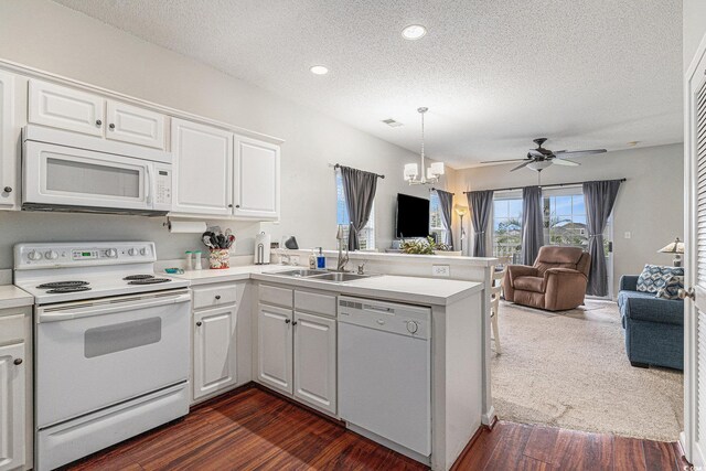 2000 Cross Gate Blvd Unit 202, Surfside Beach, SC 29575 - kitchen featuring white appliances, open floor plan, a peninsula, a textured ceiling, and white cabinets