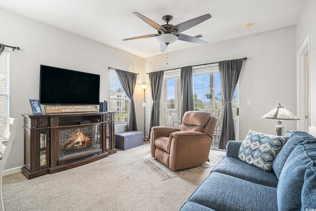 2000 Cross Gate Blvd Unit 202, Surfside Beach, SC 29575 - living area with ceiling fan, carpet flooring, a lit fireplace, and a textured ceiling