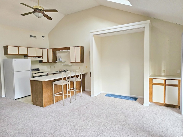 500 Fairway Village Dr Unit 9-K, Myrtle Beach, SC 29588 - kitchen featuring white appliances, light colored carpet, a peninsula, light countertops, and under cabinet range hood