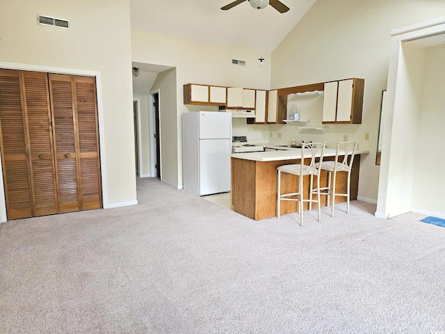 500 Fairway Village Dr Unit 9-K, Myrtle Beach, SC 29588 - kitchen with freestanding refrigerator, range, a peninsula, high vaulted ceiling, and light carpet