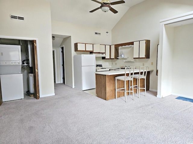 500 Fairway Village Dr Unit 9-K, Myrtle Beach, SC 29588 - kitchen featuring white appliances, stacked washer / dryer, under cabinet range hood, a peninsula, and ceiling fan