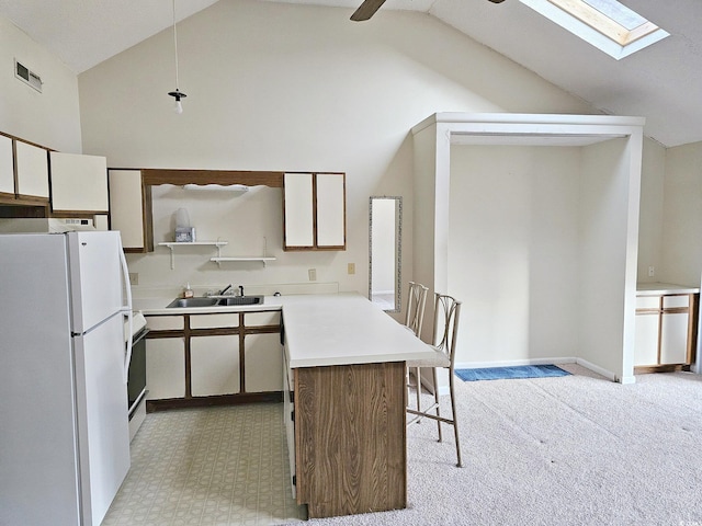 500 Fairway Village Dr Unit 9-K, Myrtle Beach, SC 29588 - kitchen featuring white appliances, a peninsula, a skylight, a breakfast bar area, and a ceiling fan