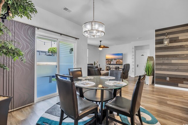 2882 Ophelia Way, Myrtle Beach, SC 29577 - dining room with a chandelier, light wood finished floors, ceiling fan, and wood walls