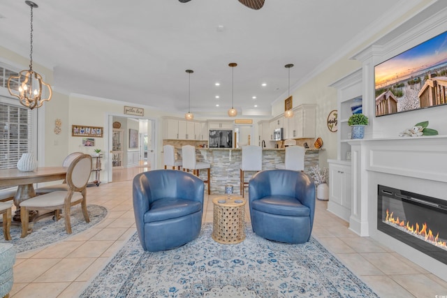 139 Olde Canal Loop, Pawleys Island, SC 29585 - living room featuring light tile patterned floors, ornamental molding, a chandelier, recessed lighting, and a glass covered fireplace