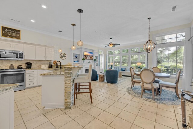 139 Olde Canal Loop, Pawleys Island, SC 29585 - kitchen with stainless steel appliances, light tile patterned floors, ornamental molding, tasteful backsplash, and open floor plan