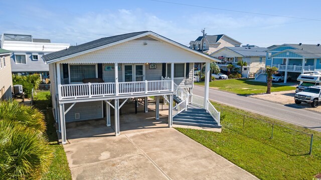 3307 Nixon St, North Myrtle Beach, SC 29582 - coastal home featuring a porch, concrete driveway, a front yard, a carport, and a residential view