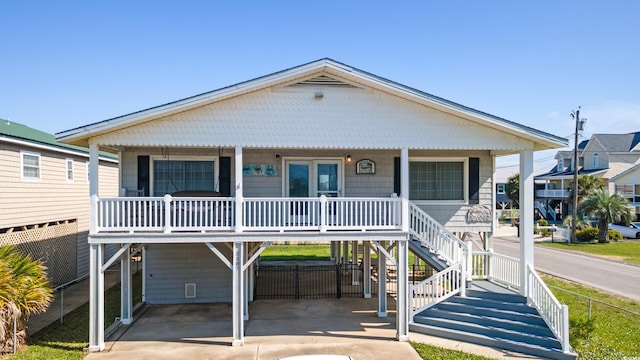 3307 Nixon St, North Myrtle Beach, SC 29582 - raised beach house featuring covered porch, concrete driveway, stairs, and a carport
