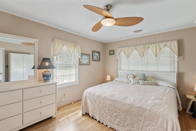 3307 Nixon St, North Myrtle Beach, SC 29582 - bedroom featuring light wood-style flooring, a textured ceiling, ceiling fan, and crown molding