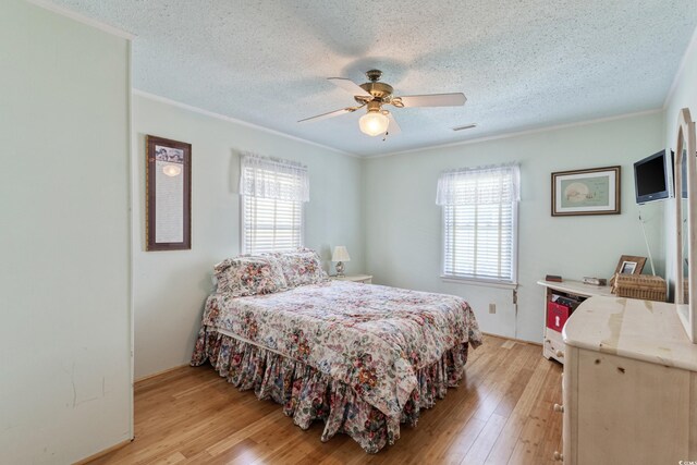 3307 Nixon St, North Myrtle Beach, SC 29582 - bedroom featuring multiple windows, ornamental molding, light wood-style floors, a textured ceiling, and ceiling fan
