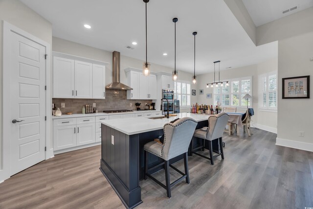 1024 Pochard Dr, Conway, SC 29526 - kitchen with wall chimney exhaust hood, a kitchen bar, white cabinetry, a kitchen island with sink, and light countertops