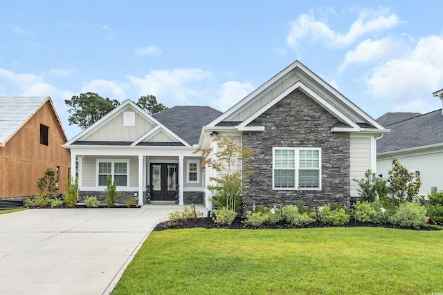 1024 Pochard Dr, Conway, SC 29526 - craftsman-style home featuring stone siding, board and batten siding, a front lawn, and french doors