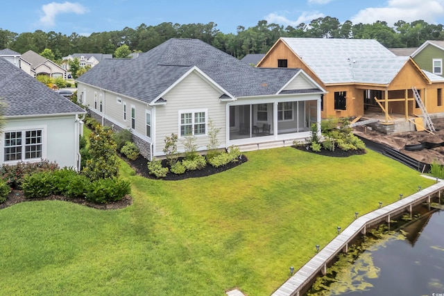 1024 Pochard Dr, Conway, SC 29526 - back of property with a sunroom, a shingled roof, a lawn, and a water view