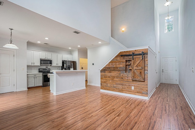 1120 Fairway Ln Unit 1120, Conway, SC 29526 - unfurnished living room featuring light wood-style flooring, a towering ceiling, ornamental molding, and recessed lighting