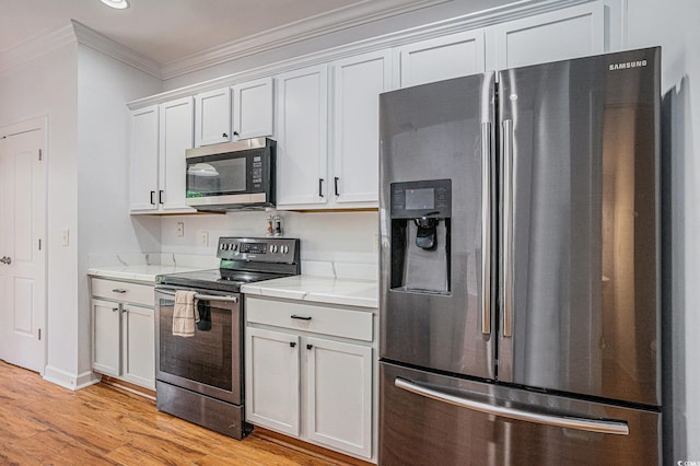 1120 Fairway Ln Unit 1120, Conway, SC 29526 - kitchen featuring stainless steel appliances, crown molding, light wood-style floors, white cabinets, and light stone countertops