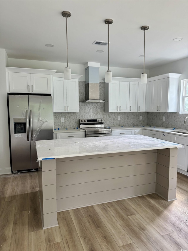 2075 Lees Landing Cir, Conway, SC 29526 - kitchen with appliances with stainless steel finishes, wall chimney exhaust hood, white cabinets, backsplash, and light wood-style flooring