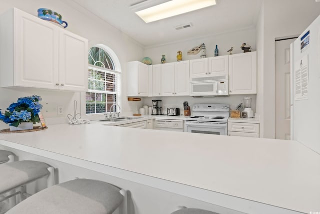 4261 Hibiscus Dr Unit 4-104, Little River, SC 29566 - kitchen with white appliances, ornamental molding, white cabinets, light countertops, and a breakfast bar