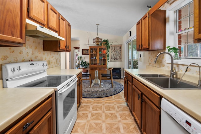 1145 Forest Dr, North Myrtle Beach, SC 29582 - kitchen featuring white appliances, under cabinet range hood, lofted ceiling, light countertops, and brown cabinets