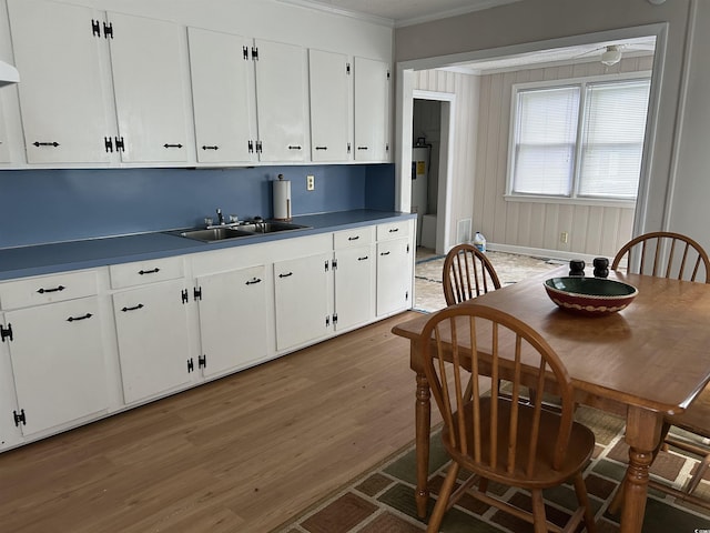 404 E Andrews St, Hemingway, SC 29554 - kitchen with crown molding, white cabinets, light wood-type flooring, and dark countertops