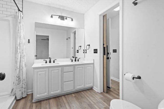 1331 Bermuda Ct, Surfside Beach, SC 29575 - full bathroom with wood finished floors, double vanity, a shower with curtain, and a textured ceiling